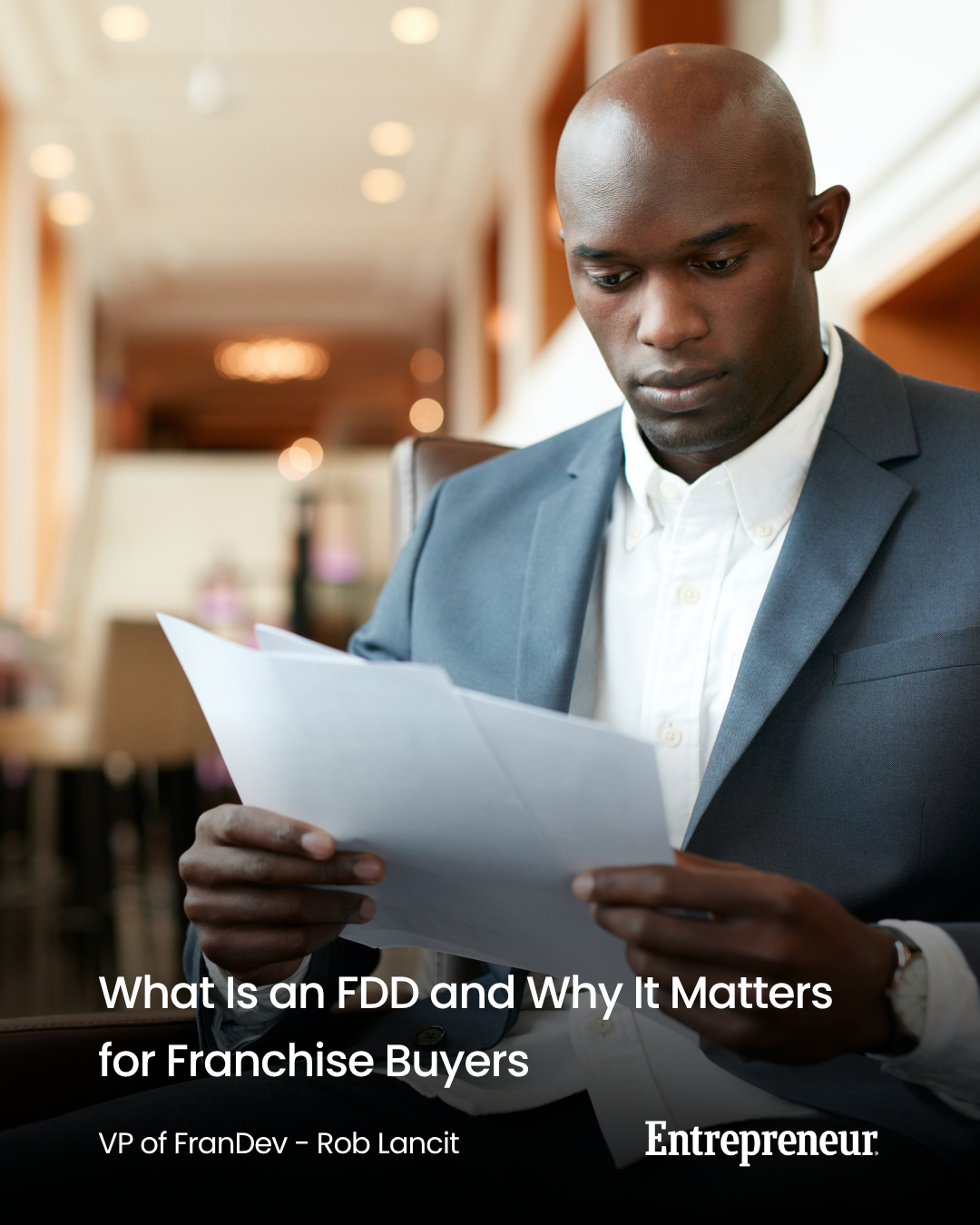 A man reading a franchise disclosure document in a lobby